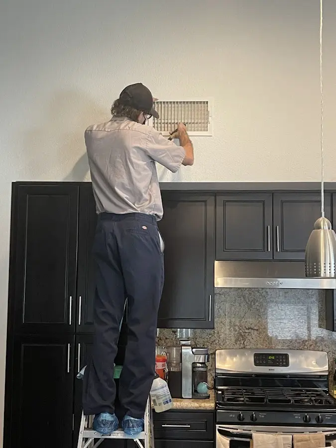 Technician inspecting an air vent during HVAC service in Rancho Mission Viejo